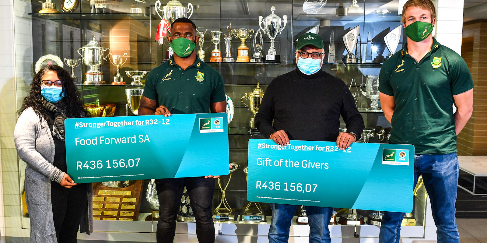 Siya Kolisi and Pieter-Steph du Toit hand over the money raised during the #StrongerTogether for R32-12 campaign