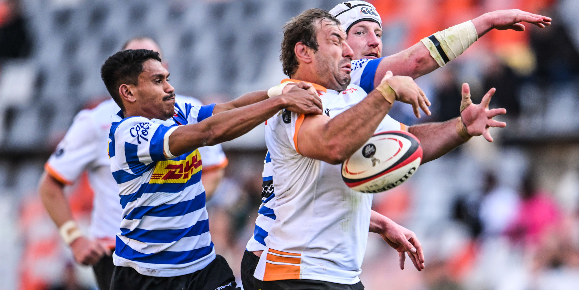 Jeandre Rudolph of the Toyota Cheetahs tries to evade two DHL WP players.